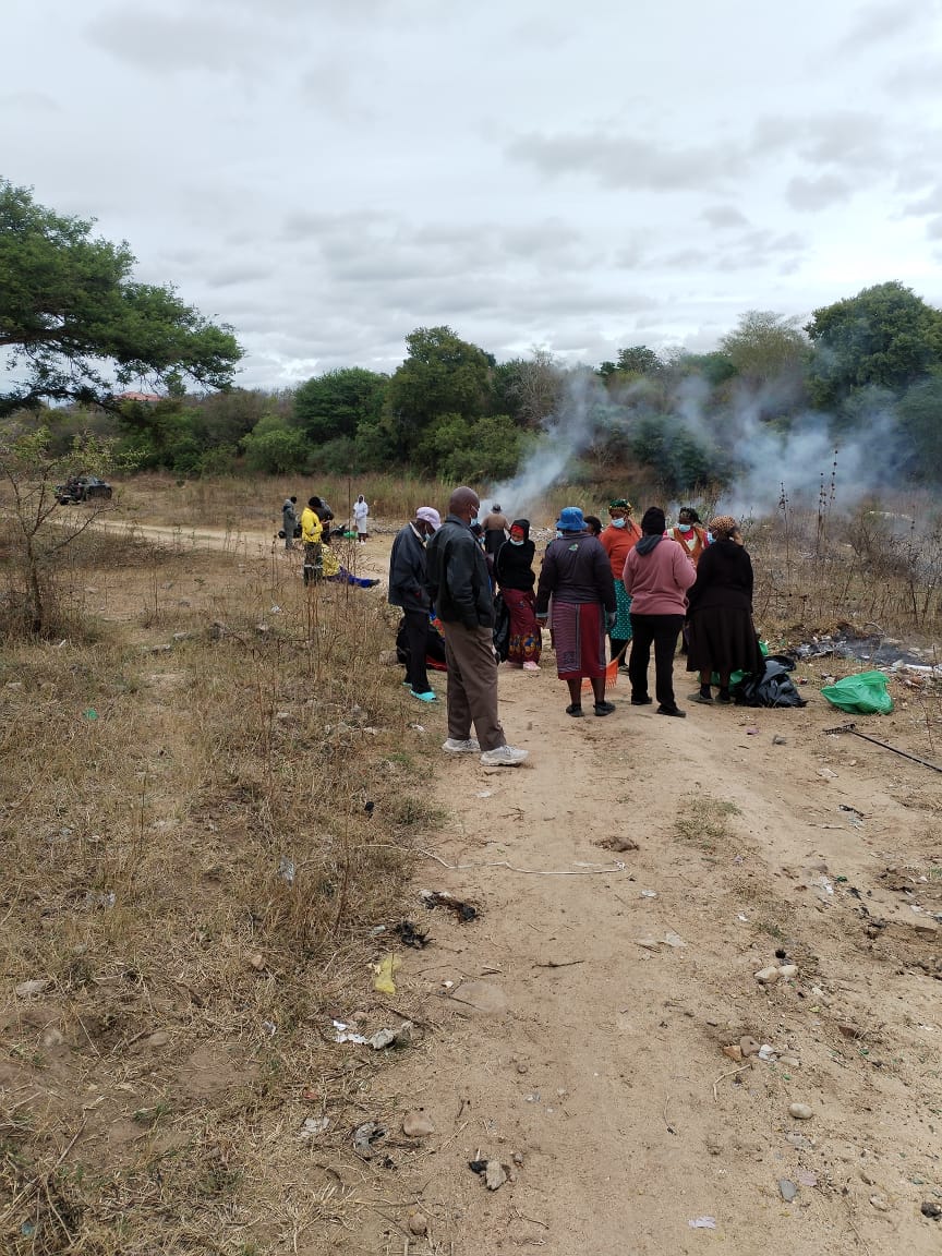 Community group gathered around debris near the river.