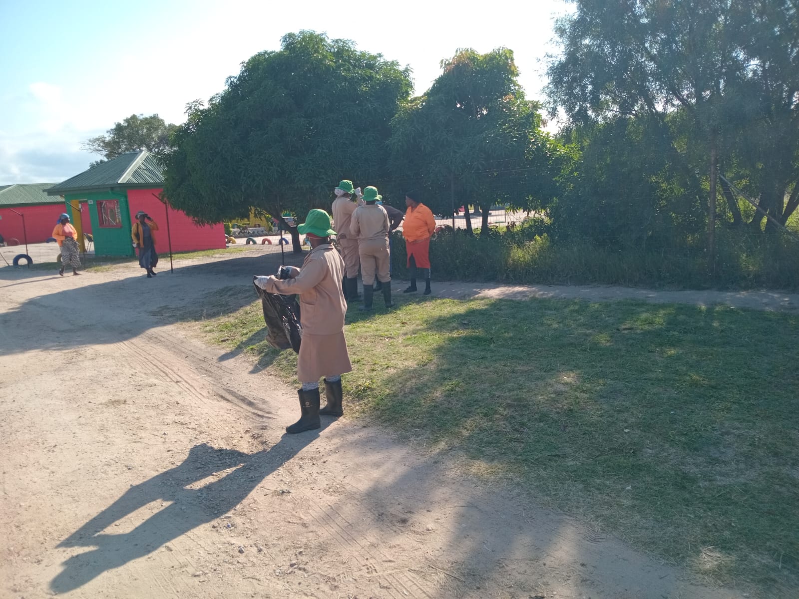 A volunteer carrying a collection bag, walking through the village.